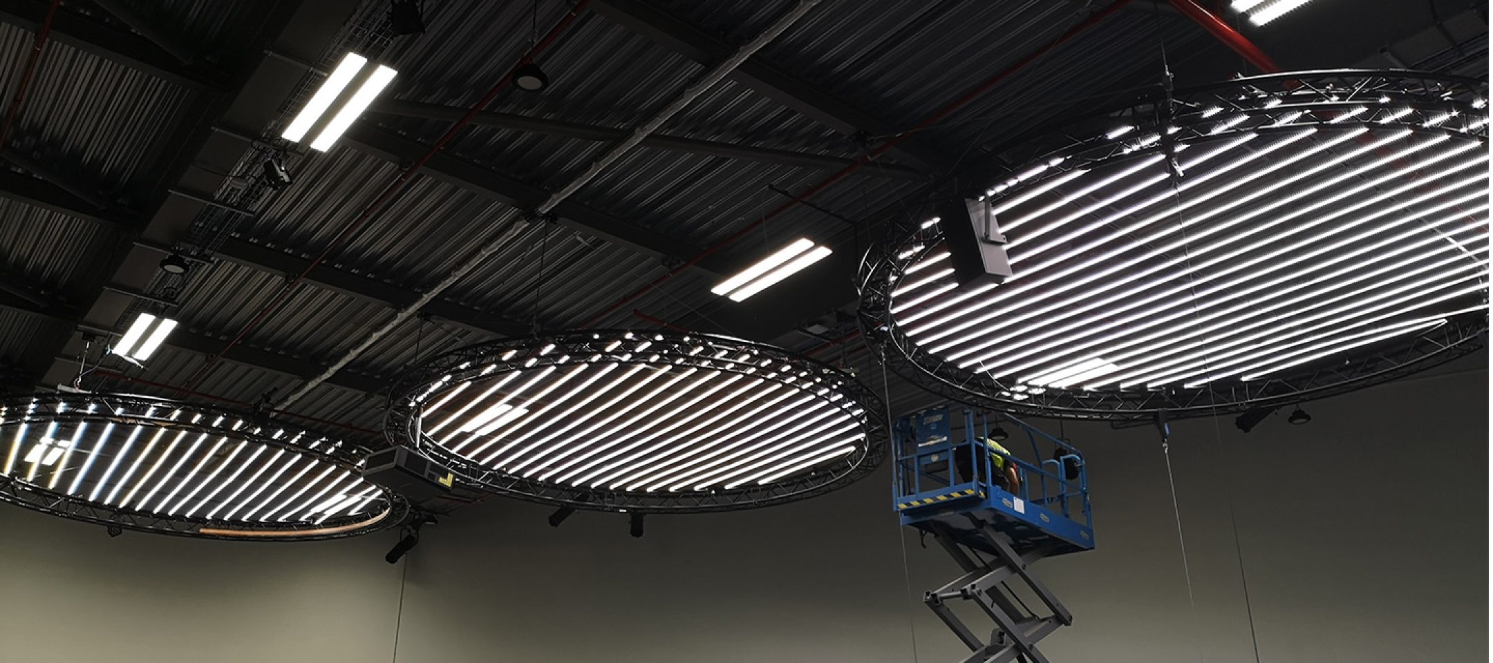 Rigger installing lighting on a truss circle.