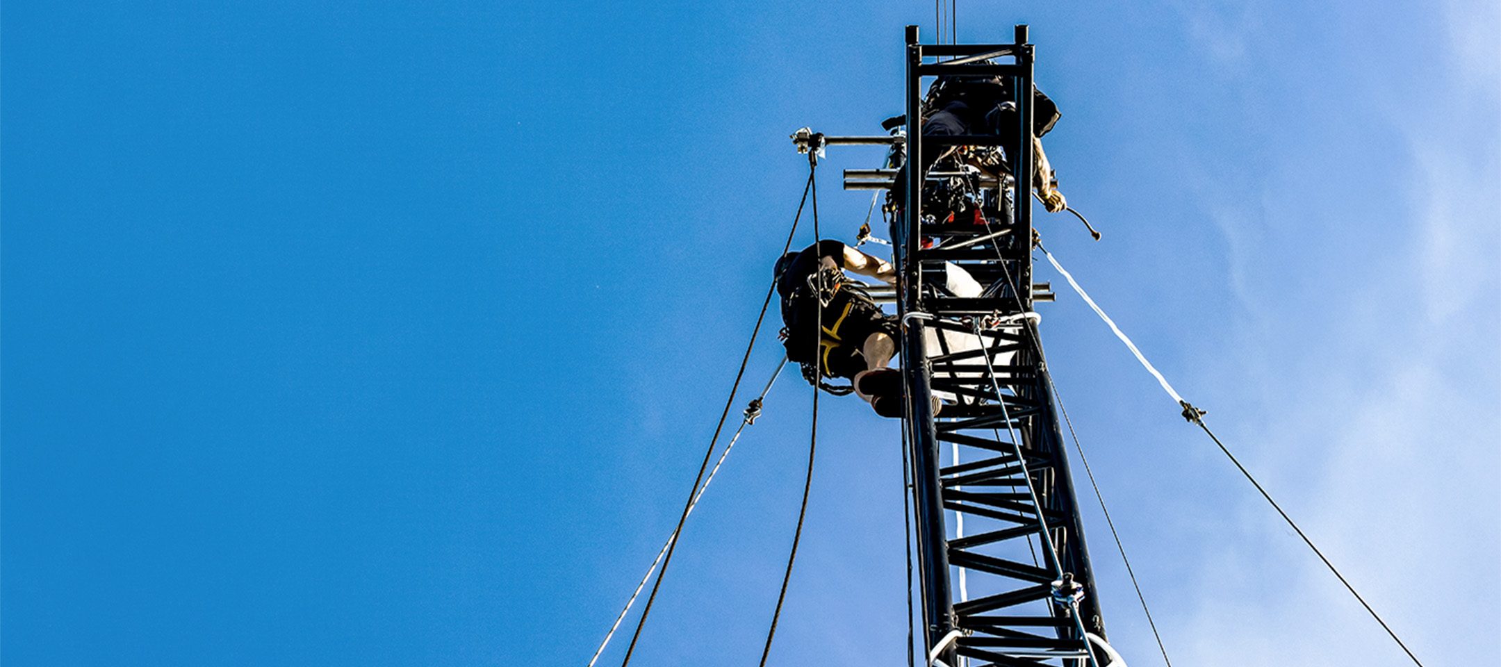 Rigger working at height, climbing a truss tower using a rope access solution